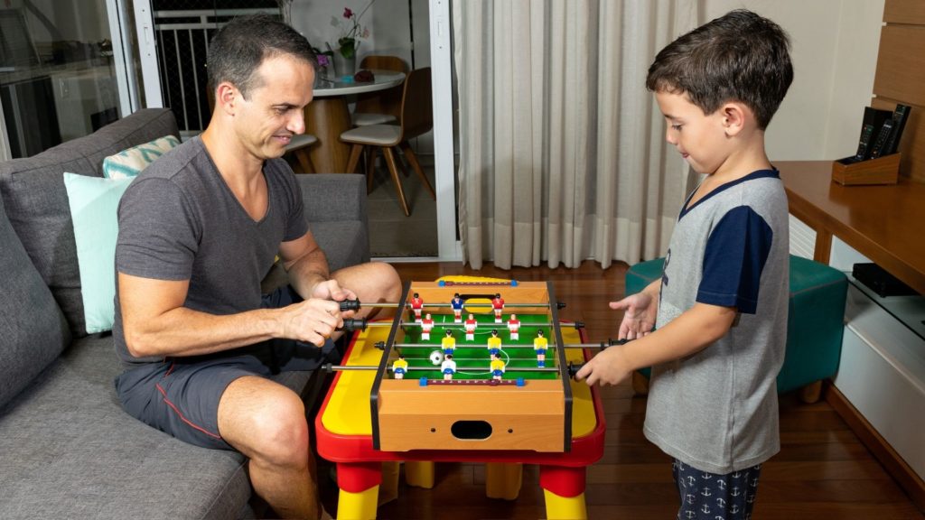 Picture of father and son playing foosball.