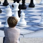 Picture of a boy staring at a chess board.