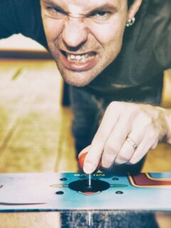 Picture of a person playing a coffee table arcade game.