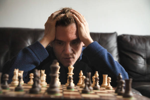 A picture of a person trying to learn chess.